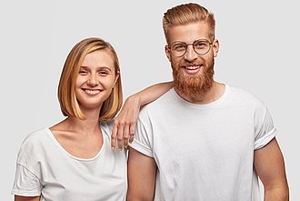Mann und Frau in weißem Shirt lächeln in Kamera